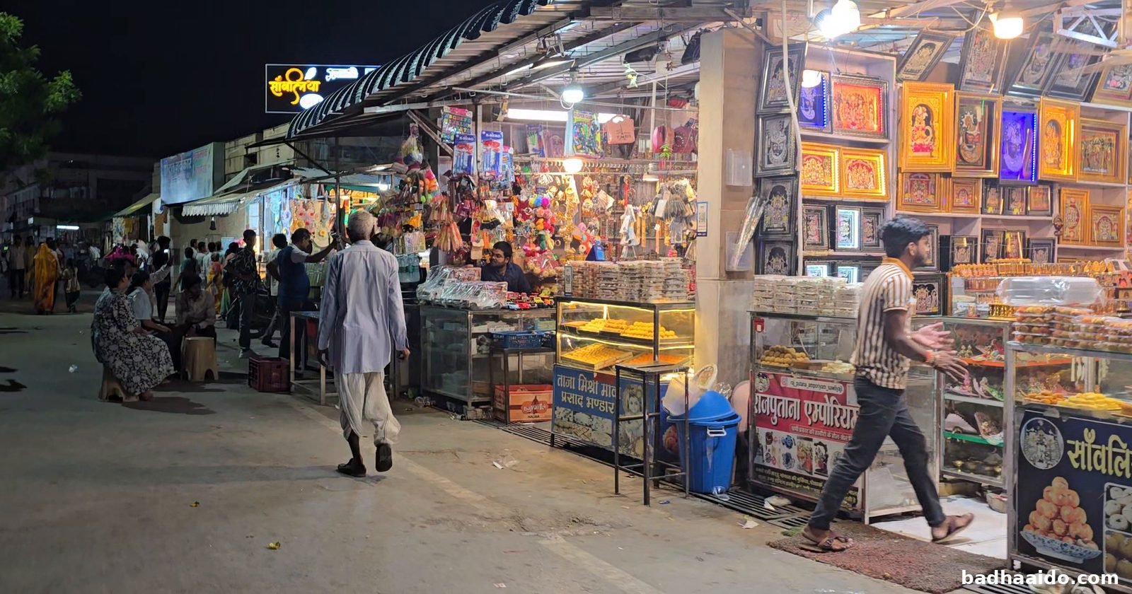 मंदिर के बाहर प्रसाद और तस्वीरों की दुकानें